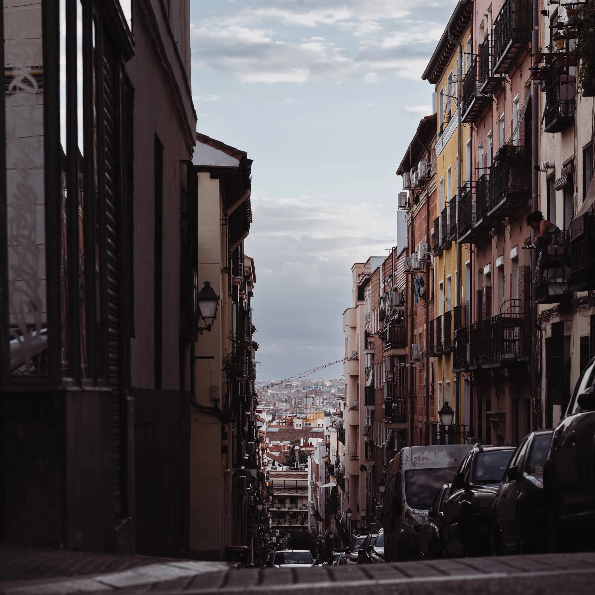 A city street descending toward the Madrid skyline